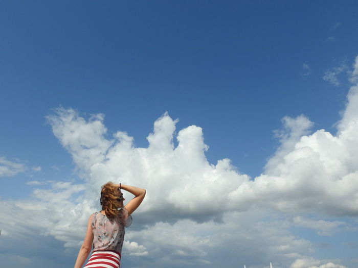 Rear view of woman against blue sky