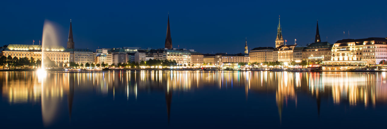 Reflection of buildings in lake at night