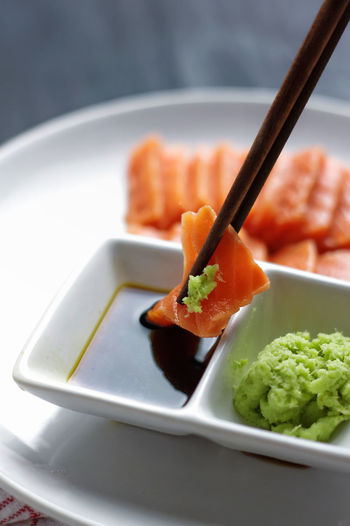 Close-up of salmon wasabi dipped in soy sauce