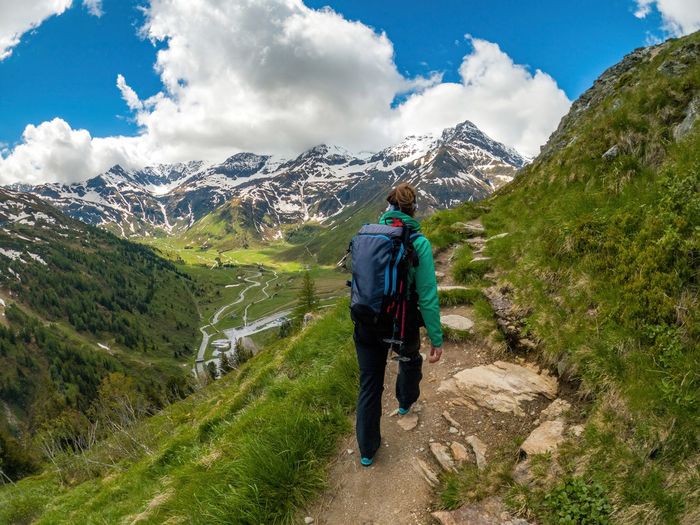 Woman hiking on footpath in the austrian alps near gastein, salzburg, austria