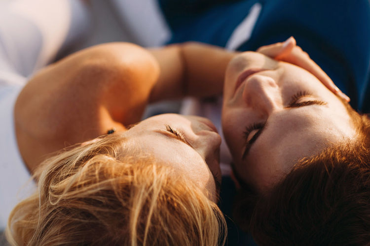 CLOSE-UP PORTRAIT OF YOUNG WOMAN RELAXING IN SUNLIGHT