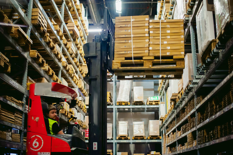 Worker driving forklift in factory