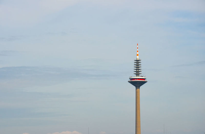 Communications tower on building against sky