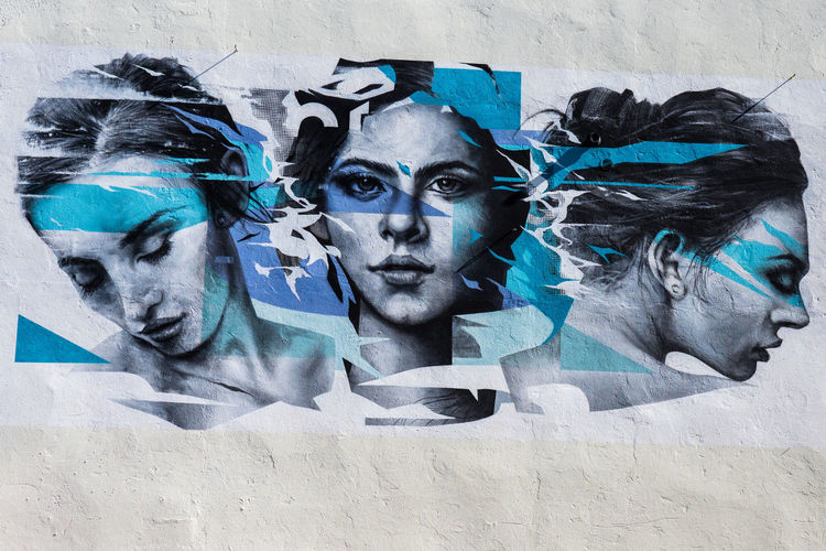 Portrait of young woman against graffiti wall