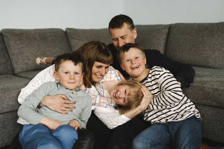 Portrait of happy family sitting on sofa at home