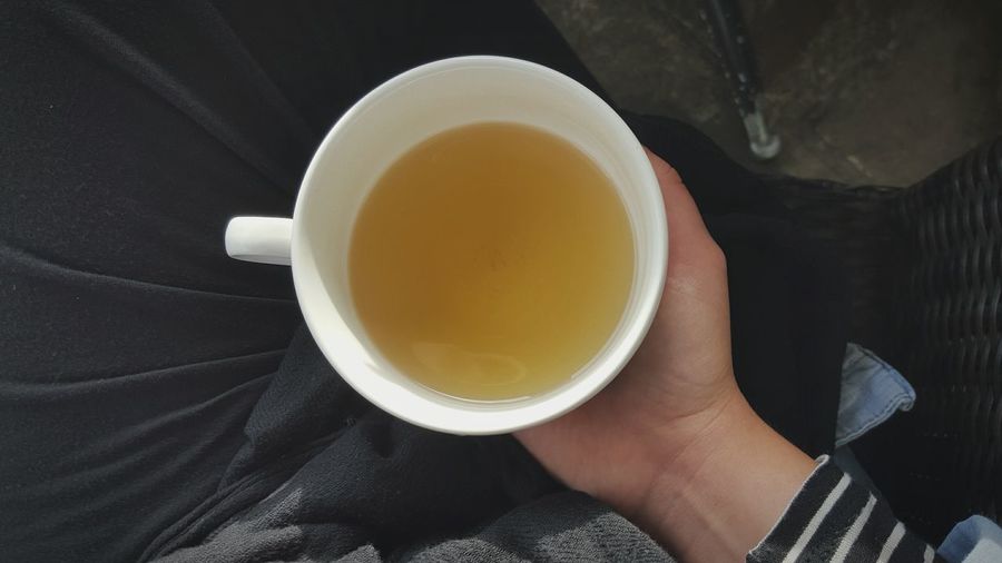 Cropped image of woman holding chamomile tea