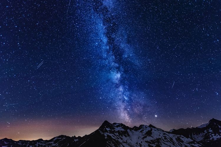 Milky way over snow covered mountains in austrian alps