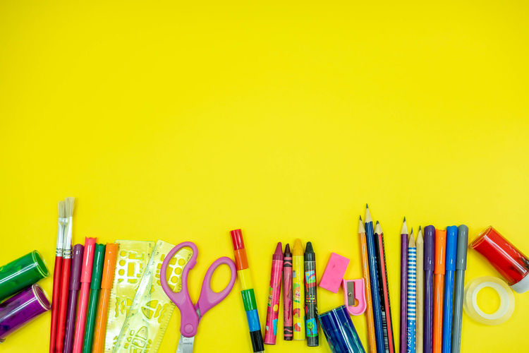 Close-up of colored pencils against yellow background