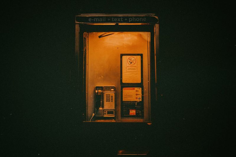 Illuminated telephone booth at night