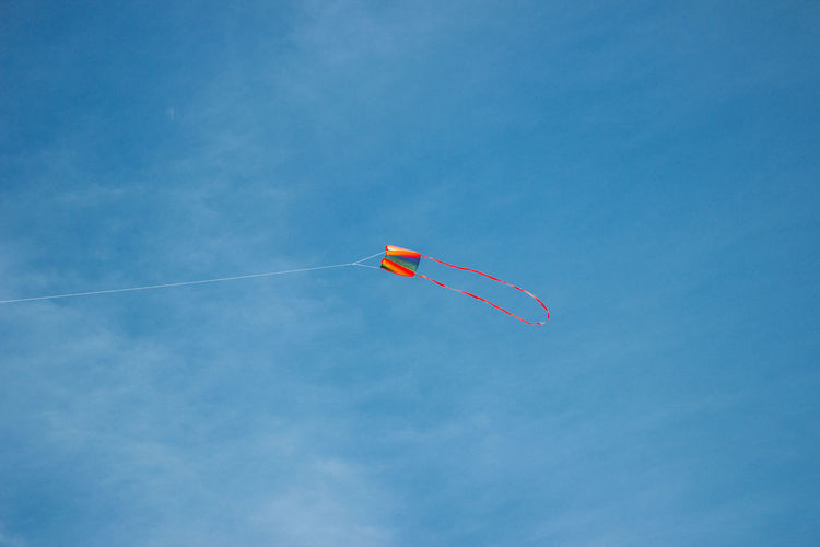 Low angle view of kite flying against blue sky.