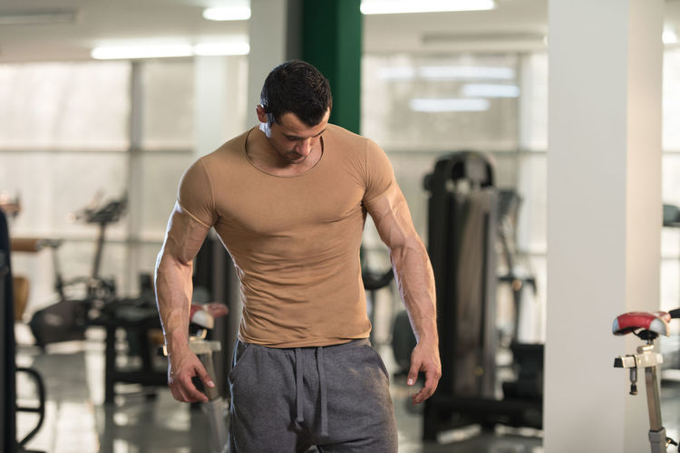 Muscular man standing in gym