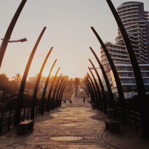 People walking on footpath at sunset