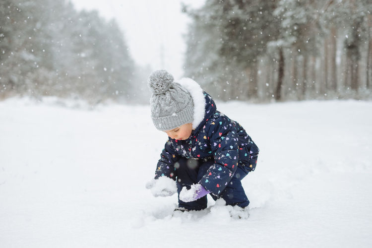 Toddler child playing in snow
