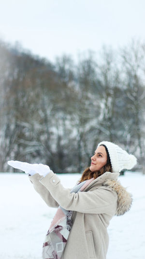 Woman standing on snow covered tree
