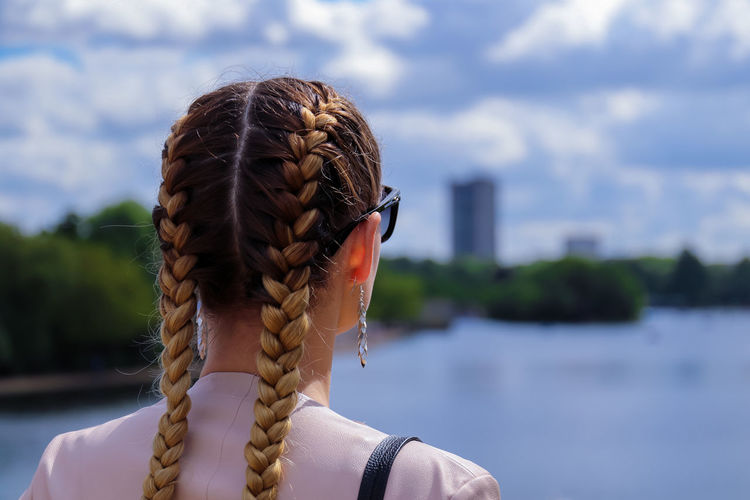 Rear view of woman with braided hair looking at river