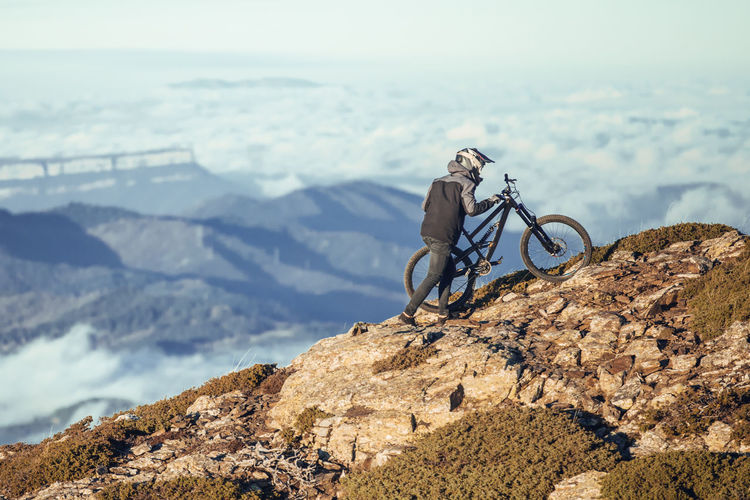 Rear view of man riding bicycle on mountain