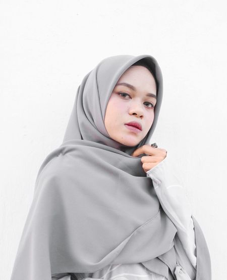 Portrait of woman wearing headscarf against white background