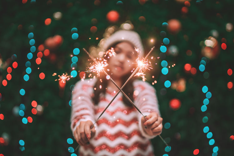 Woman holding sparklers at night