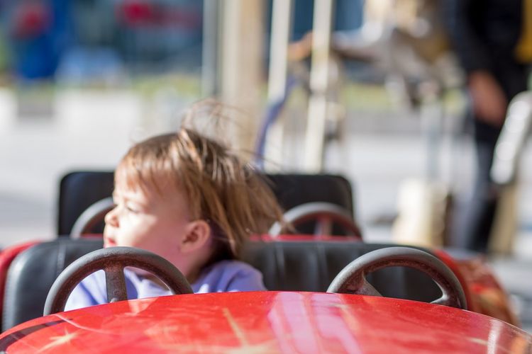 Baby girl sitting on amusement park ride