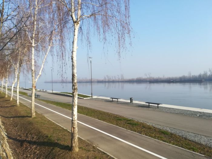 Road by lake against clear sky