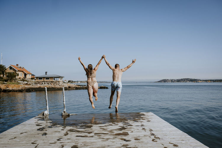 Couple jumping into sea