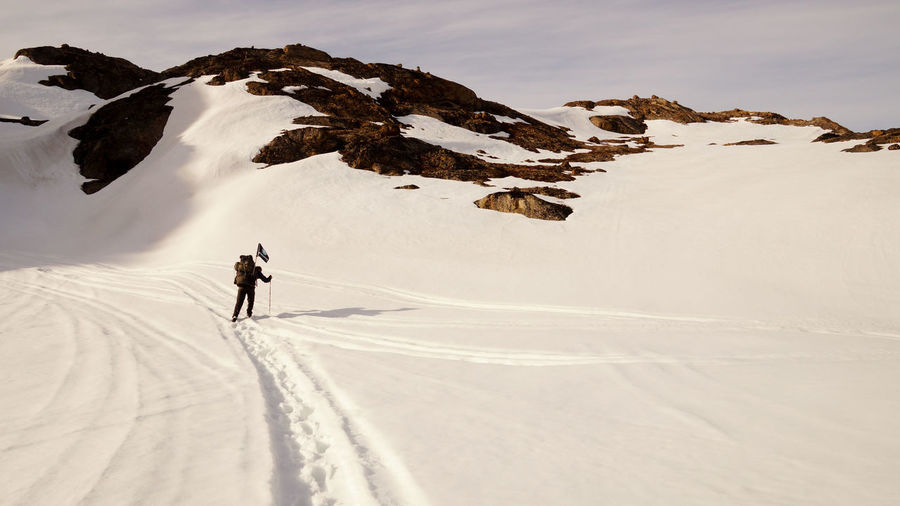 Rear view of person skiing on snowcapped mountain