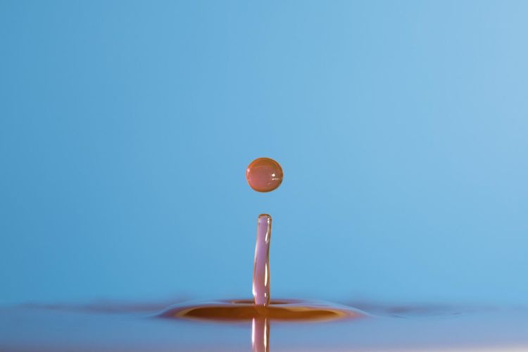 Close-up of water drop against blue background