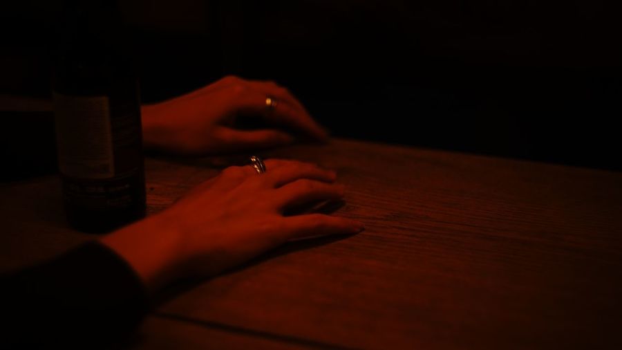 Close-up of hand holding cigarette on table
