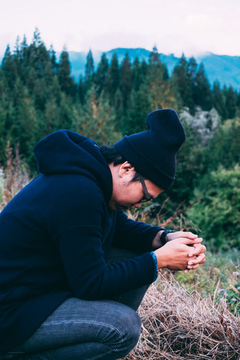 Side view of man crouching on field 