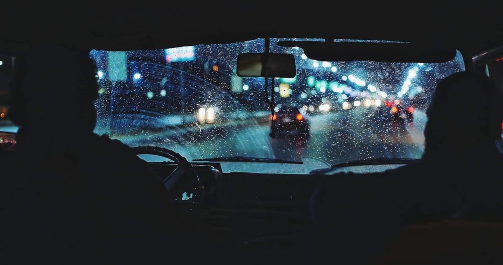 People traveling in car at night during rainy season