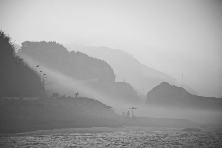 Scenic view of sea and mountains against sky