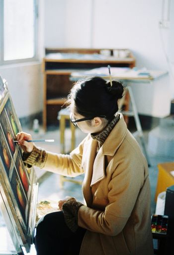 High angle view of artist painting on canvas