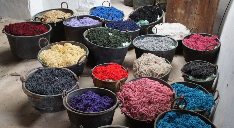 High angle view of various dyed wools in container at workshop