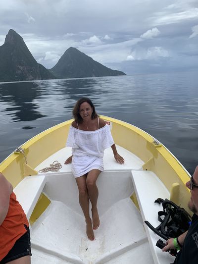 Beautiful woman  in boat on ocean against pitons 