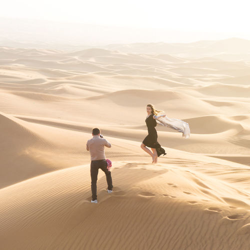 People on sand dune in desert