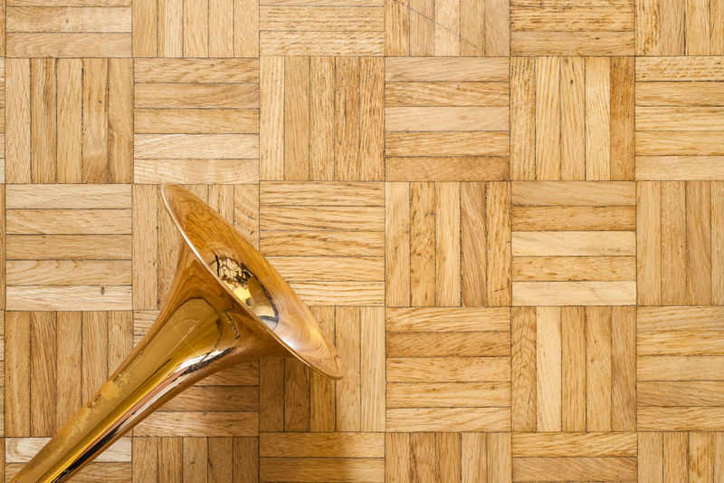 Close-up of trombone on parquet floor