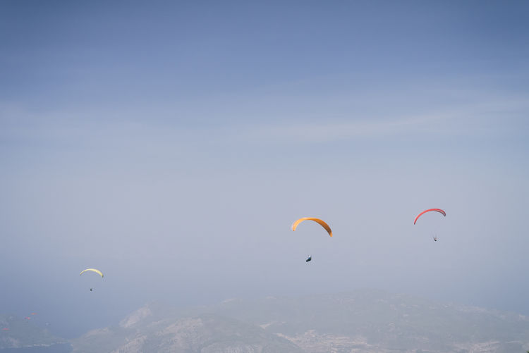 People paragliding against clear sky