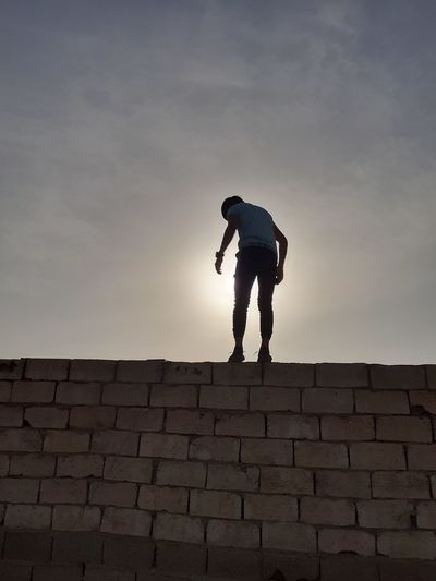 Low angle view of man standing against wall