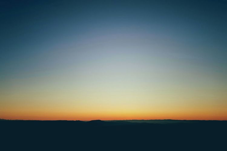 Scenic view of silhouette landscape against clear sky during sunset