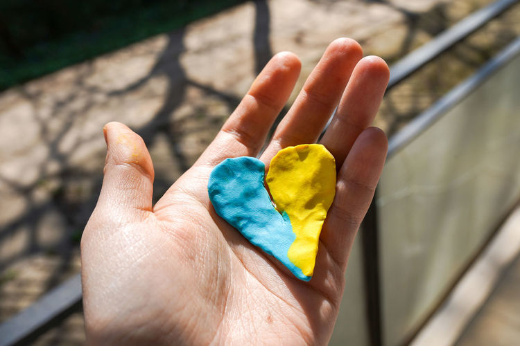 The concept of ending the war in ukraine. heart in the colors of the flag of ukraine in female hand