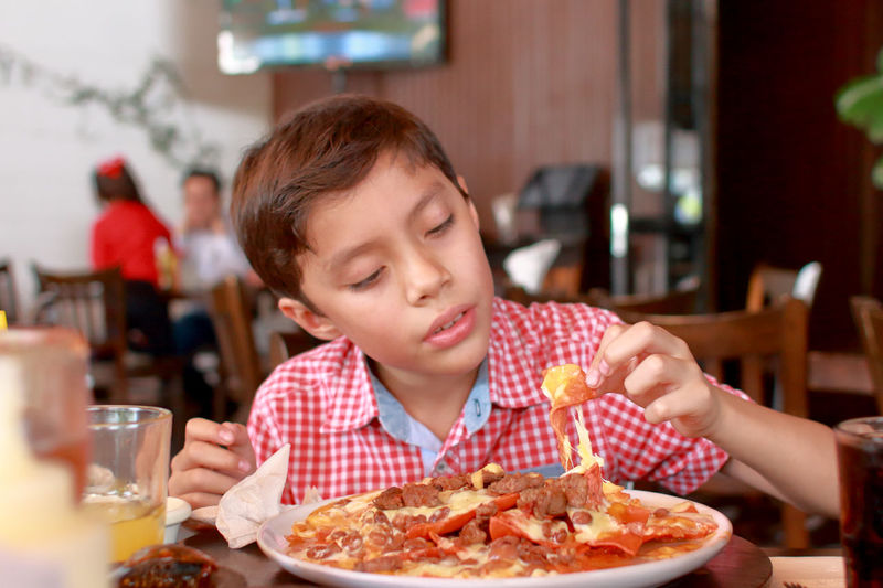 Portrait of boy eating ice cream in restaurant