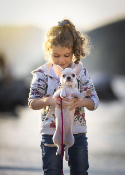 Full length of a girl holding dog