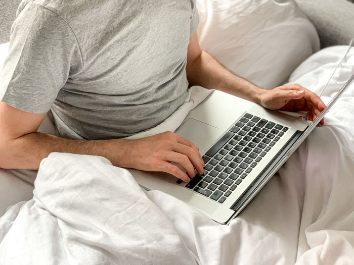 Midsection of man using laptop at home