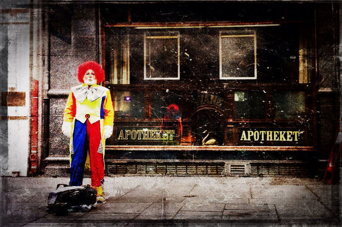 Full length a clown standing in front of a pharmacy store