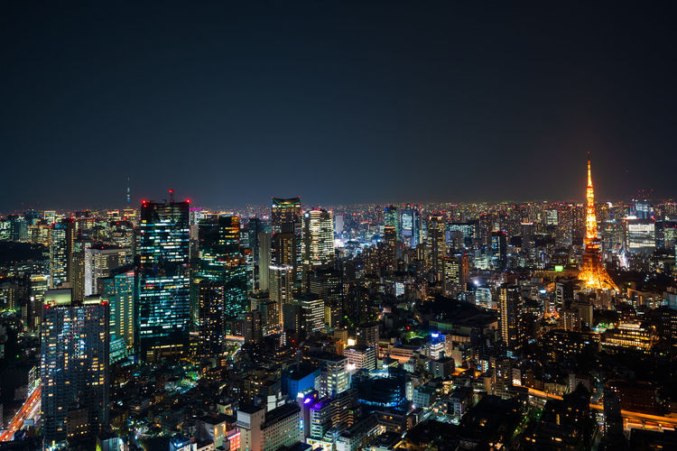 Illuminated cityscape against clear sky at night