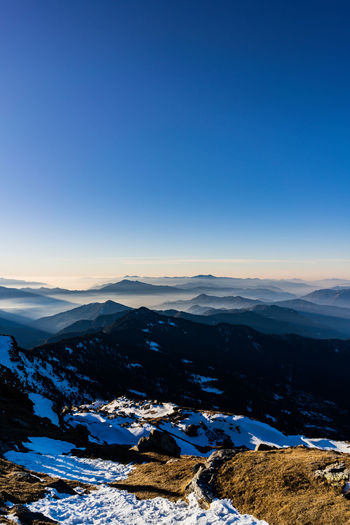 Scenic view of snowcapped mountains against clear blue sky