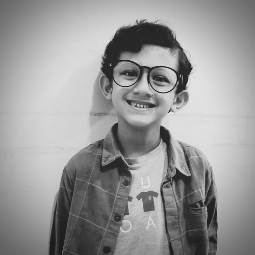 Monochrome portrait of young boys smiling wearing glasses