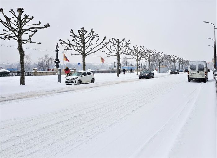 Cars on snow covered road against sky