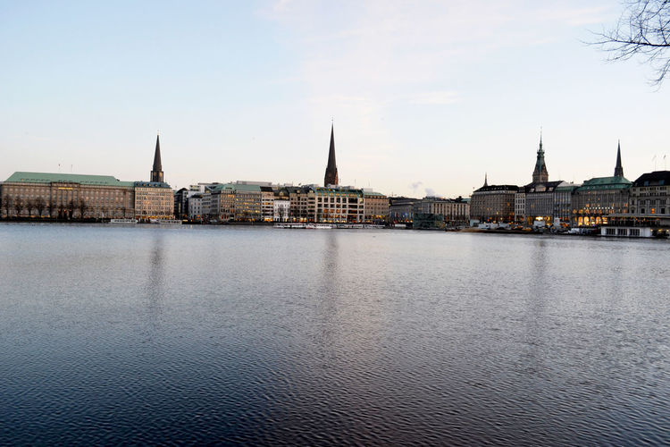 Elbe river by cityscape against sky