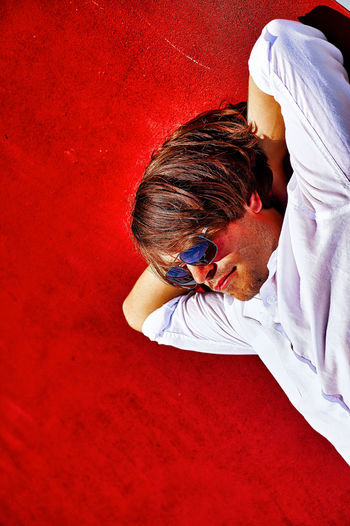 High angle view of man with sunglasses on red wall